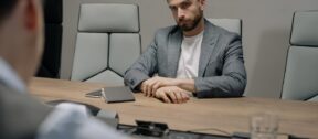 Mitarbeiter:innen richtig als Verantwortliche Beauftrage bestellen: Mann sitzt an einem Besprechungstisch