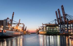 Thrive Index - Werft mit beleuchteten Containerschiffen am Abend