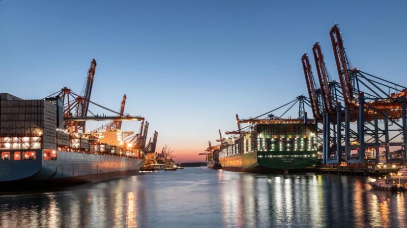 Thrive Index - Werft mit beleuchteten Containerschiffen am Abend