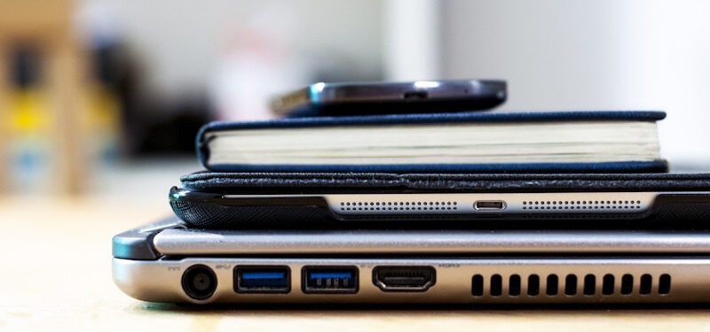 Handy auf Notizblock auf Tablet auf Laptop, Ausschnitt